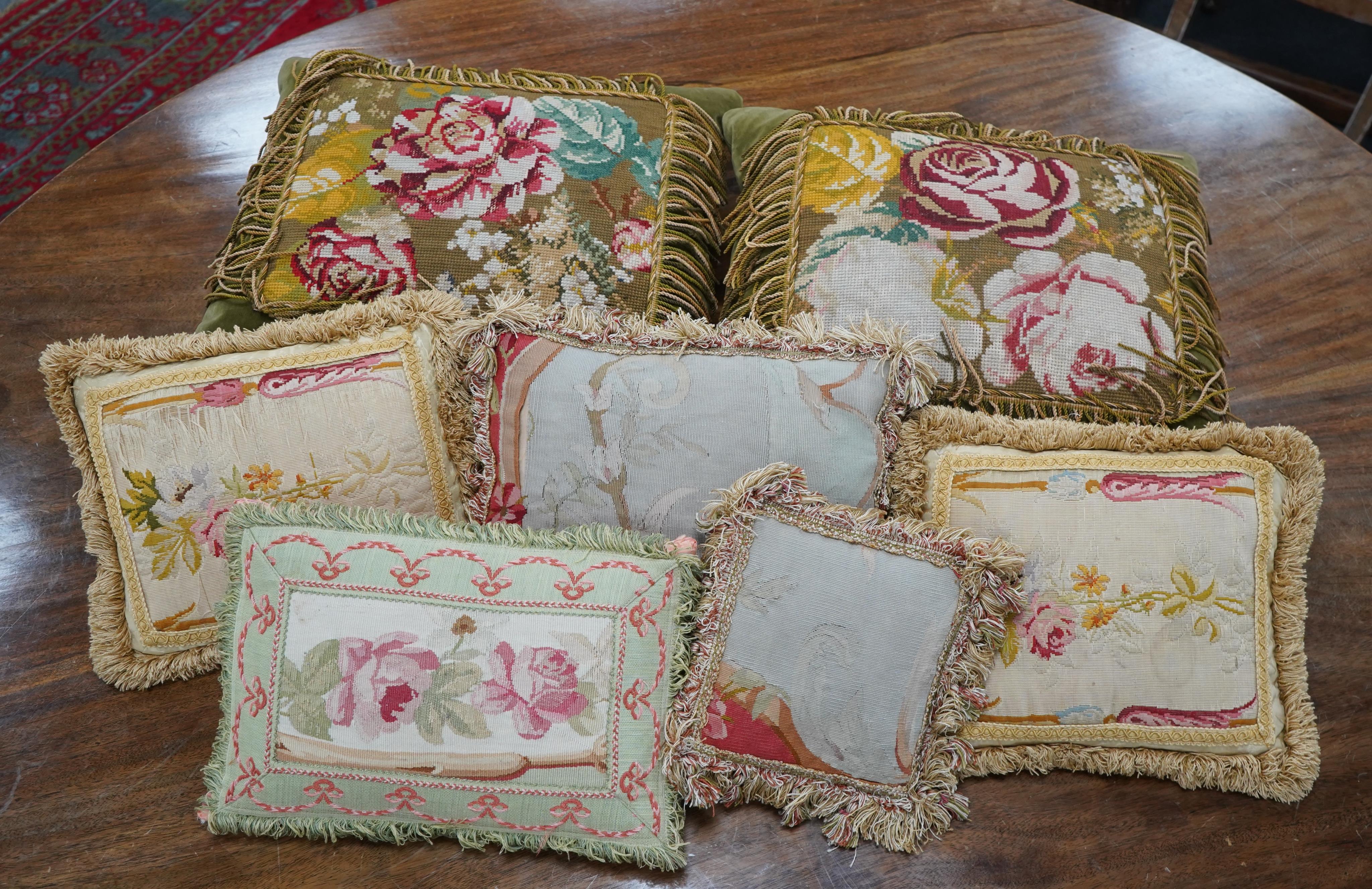 Seven 19th century cushions. Three Aubusson tapestry cushions and two machine Aubusson cushions, together with two floral wool worked cushions, all with decorative fringing. Largest 40cm x 45cm. condition - three are wor